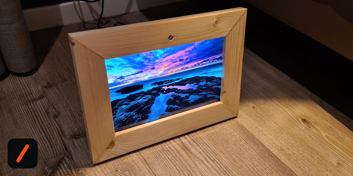 Maggi Snorrason's wooden digital picture frame showing a coastal sunset, built around a Raspberry Pi Compute Module 5
